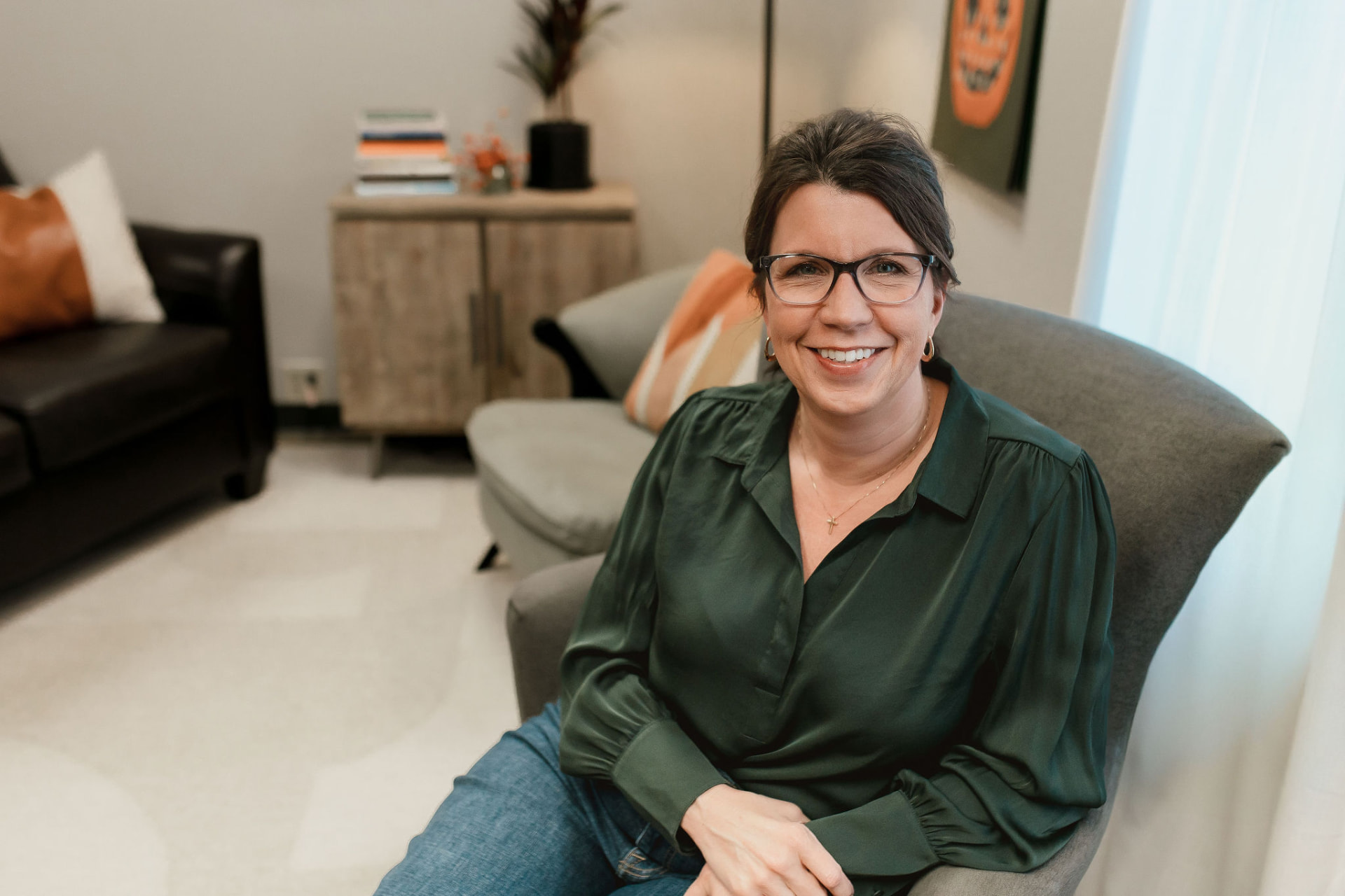 Lori Rasmussen, LISW, seated in her Waterloo, Iowa counseling office and smiling warmly
